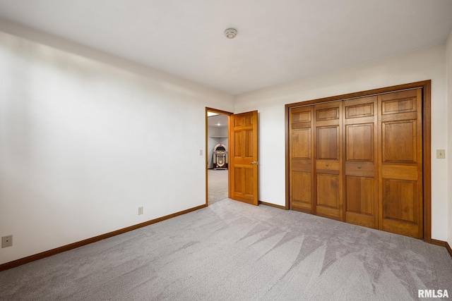 unfurnished bedroom featuring light carpet and a closet