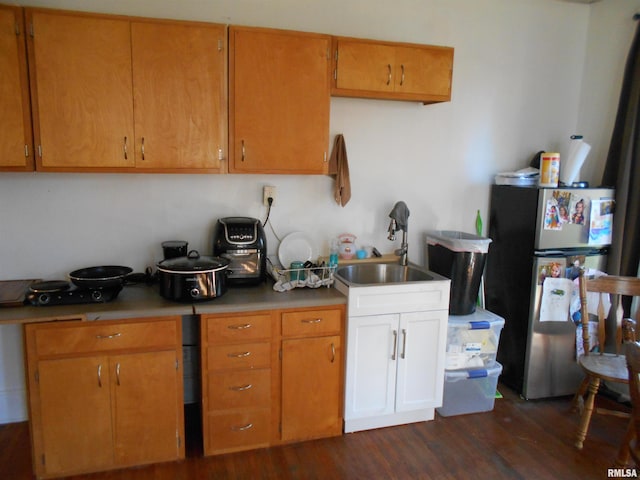 kitchen with sink, dark hardwood / wood-style flooring, and stainless steel fridge