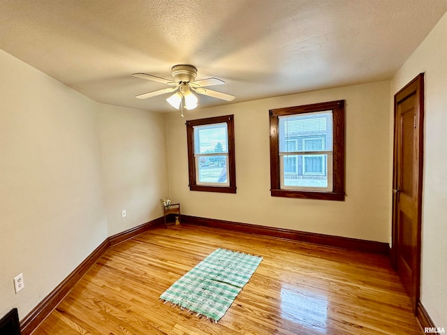 unfurnished room featuring light wood-type flooring, a textured ceiling, and ceiling fan