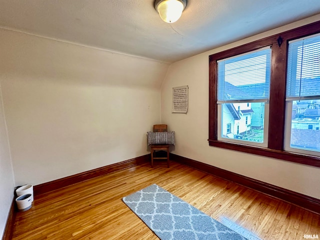 additional living space featuring hardwood / wood-style flooring and vaulted ceiling