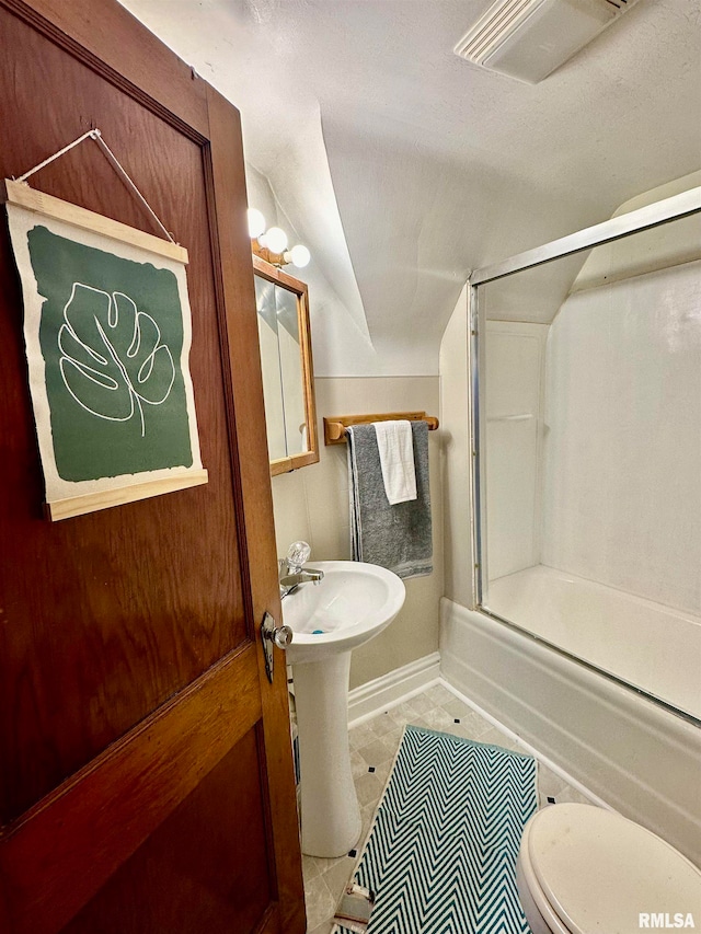 bathroom featuring bath / shower combo with glass door, tile patterned flooring, toilet, and vaulted ceiling