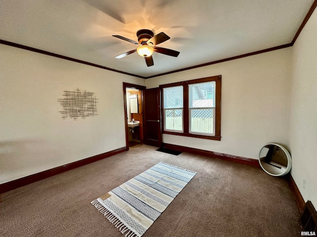 spare room featuring ceiling fan, crown molding, and carpet