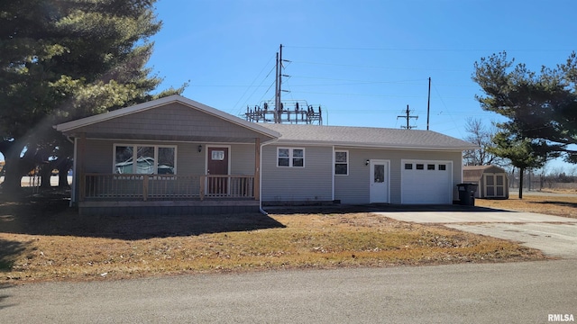 ranch-style home featuring an outbuilding, an attached garage, covered porch, driveway, and a storage unit