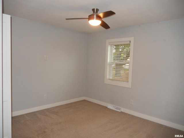 carpeted empty room with visible vents, ceiling fan, and baseboards