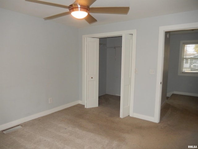 unfurnished bedroom featuring light carpet, baseboards, visible vents, ceiling fan, and a closet