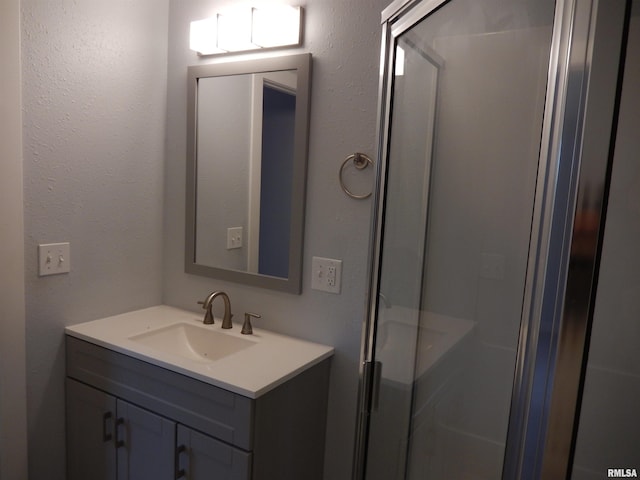 bathroom with vanity and a shower with shower door