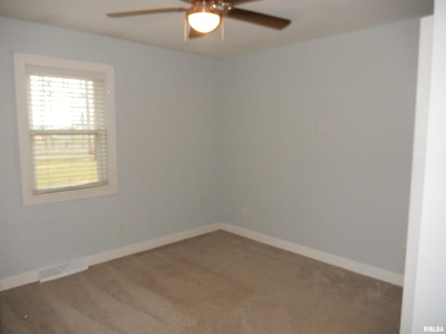 spare room with carpet floors, baseboards, visible vents, and ceiling fan