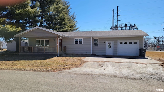 ranch-style home featuring an attached garage, covered porch, driveway, and a front lawn