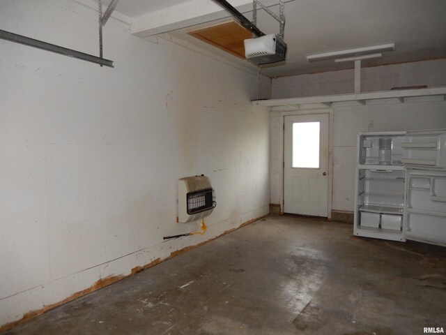 garage featuring a garage door opener and heating unit