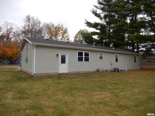 back of house featuring central AC and a yard