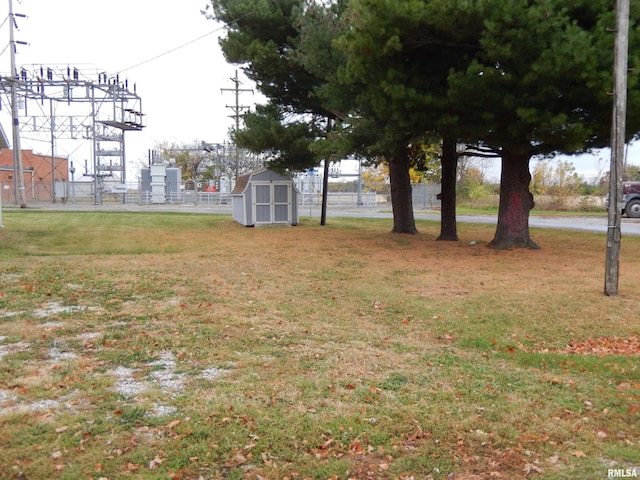 view of yard with an outdoor structure, a storage shed, and fence