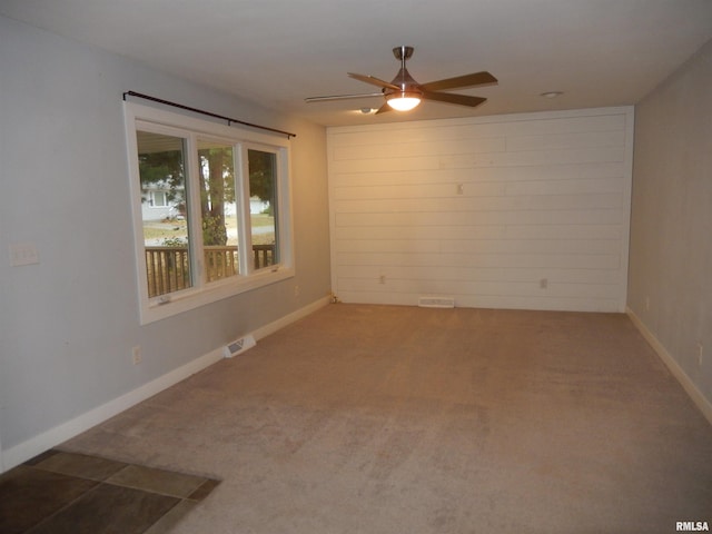 unfurnished room featuring ceiling fan, carpet floors, visible vents, and baseboards