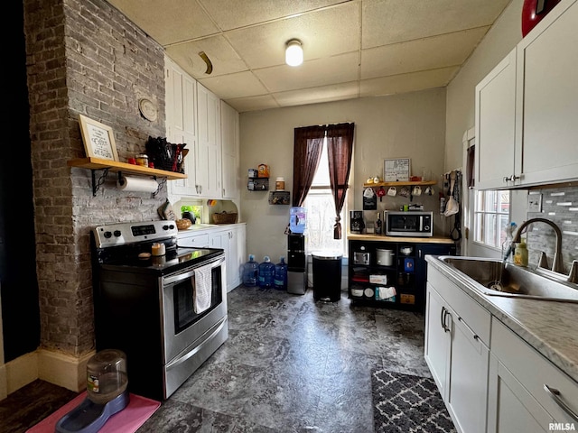 kitchen featuring appliances with stainless steel finishes, white cabinetry, sink, and a paneled ceiling