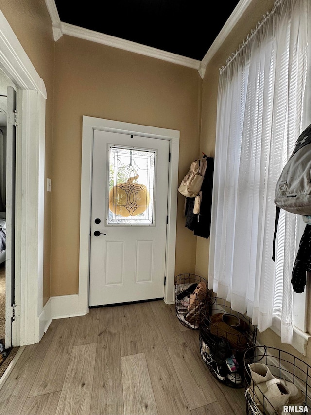 entryway with ornamental molding and light wood-type flooring