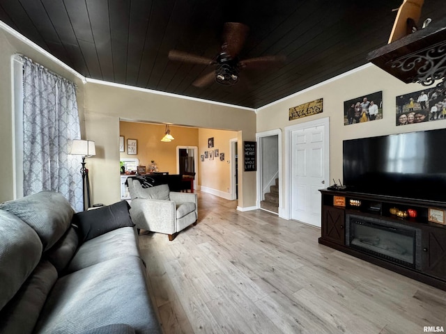 living room featuring wood ceiling, ornamental molding, light hardwood / wood-style flooring, and ceiling fan