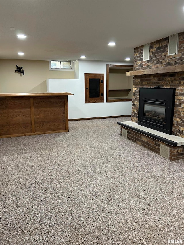 unfurnished living room featuring carpet and a brick fireplace