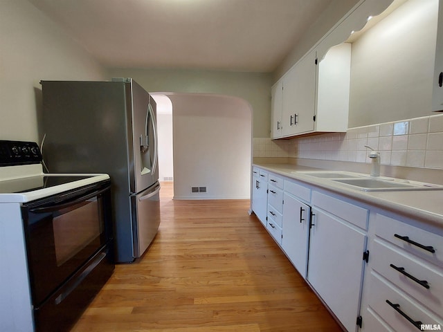 kitchen featuring tasteful backsplash, sink, light wood-type flooring, electric stove, and white cabinets