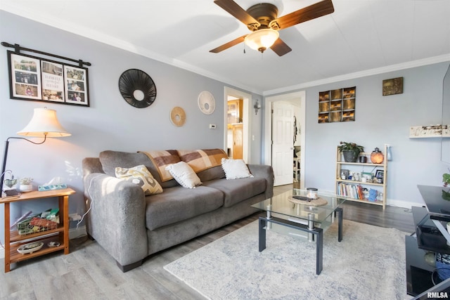 living room with hardwood / wood-style floors, ornamental molding, and ceiling fan