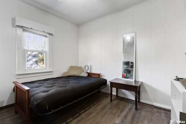 bedroom featuring ornamental molding and dark hardwood / wood-style floors