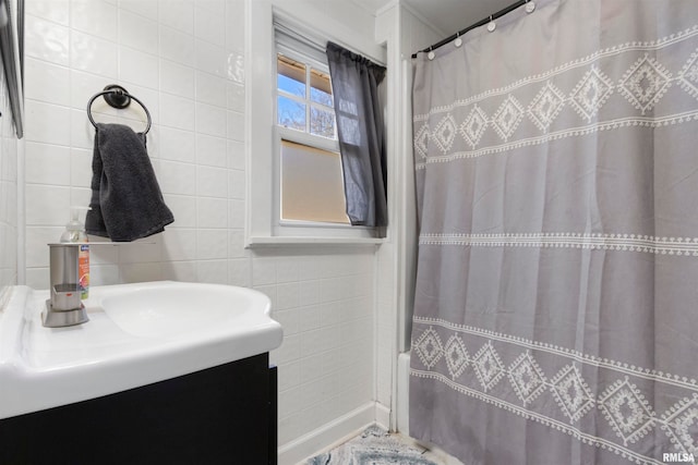 bathroom with vanity, tile walls, and shower / bath combo