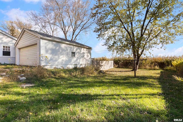 exterior space featuring a garage, a yard, and an outbuilding