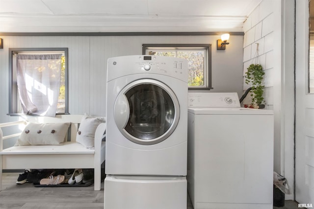 washroom with separate washer and dryer, crown molding, and hardwood / wood-style flooring