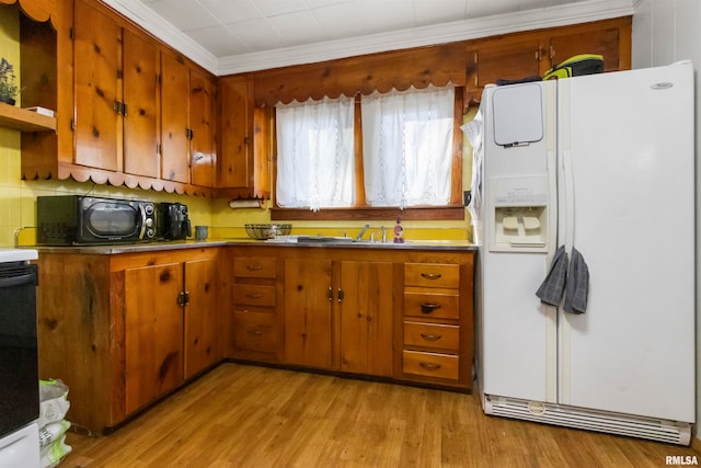 kitchen featuring crown molding, white refrigerator with ice dispenser, decorative backsplash, and light wood-type flooring