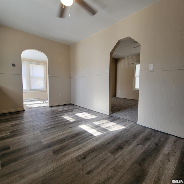 unfurnished room featuring dark wood-type flooring and ceiling fan