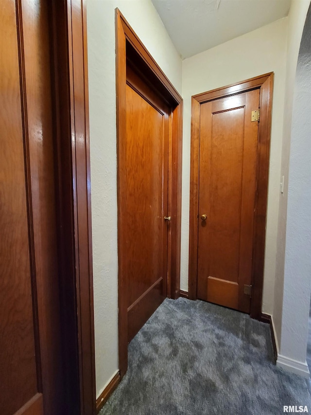 hallway with dark colored carpet