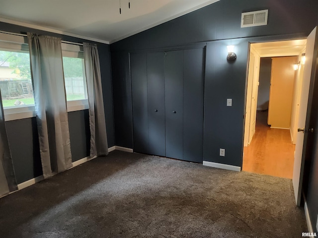 unfurnished bedroom featuring a closet, lofted ceiling, and carpet floors