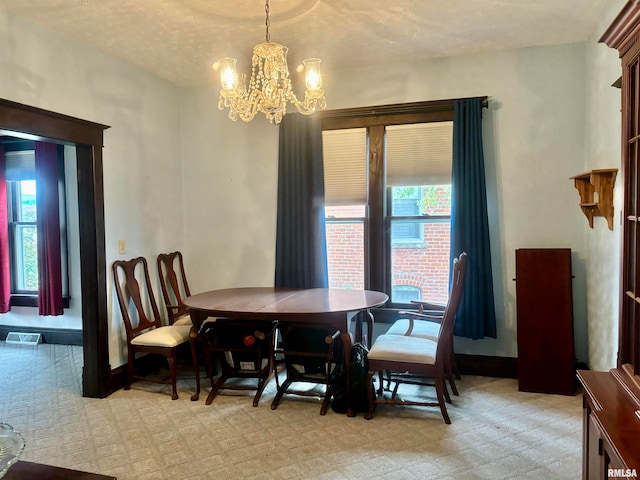 carpeted dining space with a chandelier and a textured ceiling