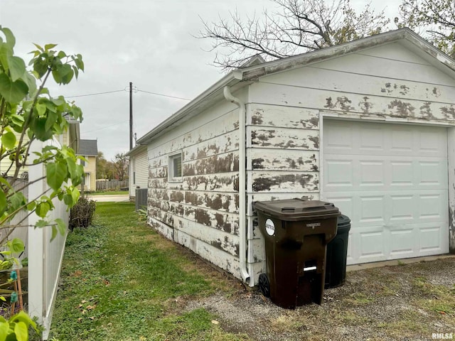 view of side of home with a garage and an outbuilding