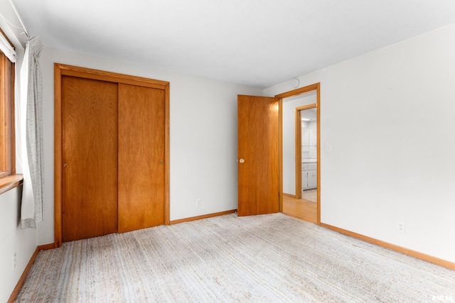 unfurnished bedroom featuring light hardwood / wood-style flooring and a closet