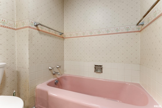 bathroom featuring toilet and a tub