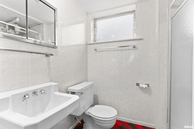 bathroom with sink, tile walls, and toilet