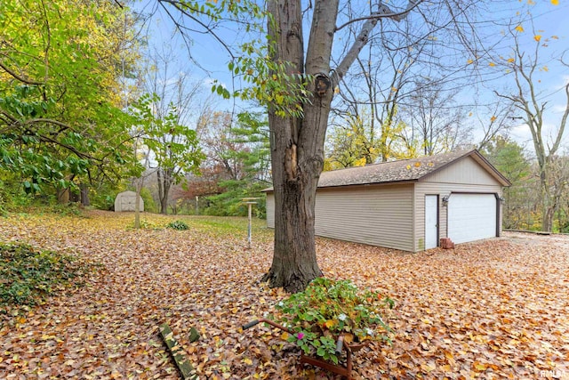 view of yard with a garage and an outbuilding