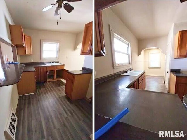 kitchen with dark wood-type flooring, kitchen peninsula, a wealth of natural light, and sink