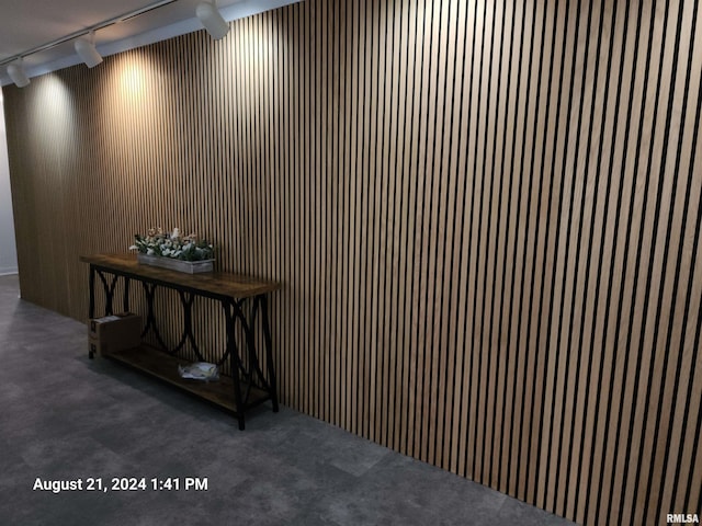 details featuring wood walls and track lighting