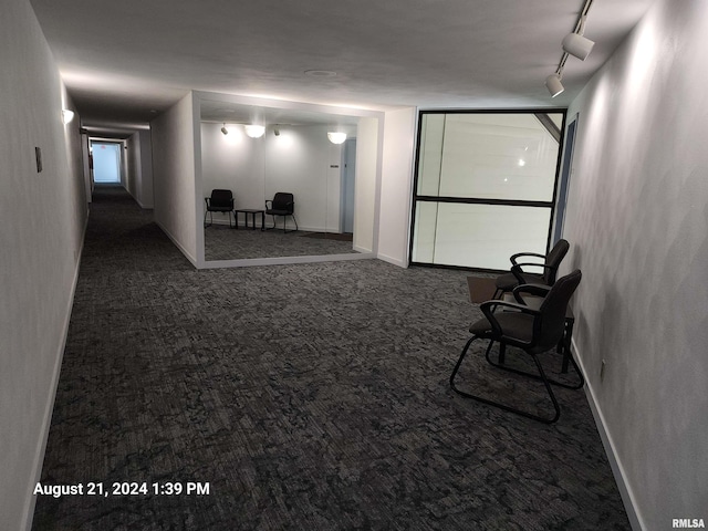 interior space with track lighting and dark colored carpet