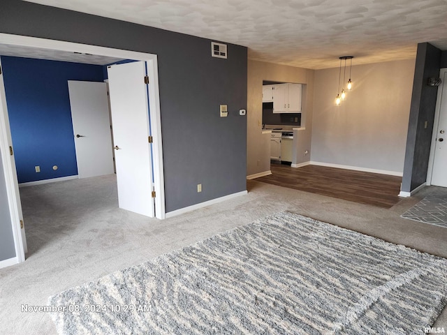 carpeted empty room featuring a textured ceiling