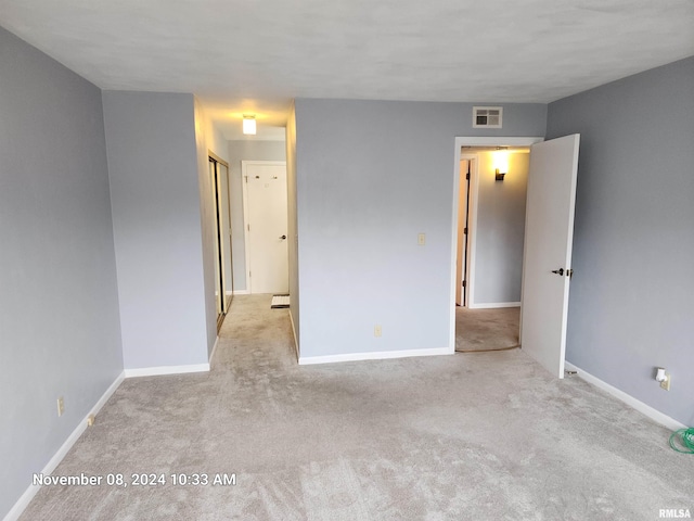 unfurnished room featuring light carpet