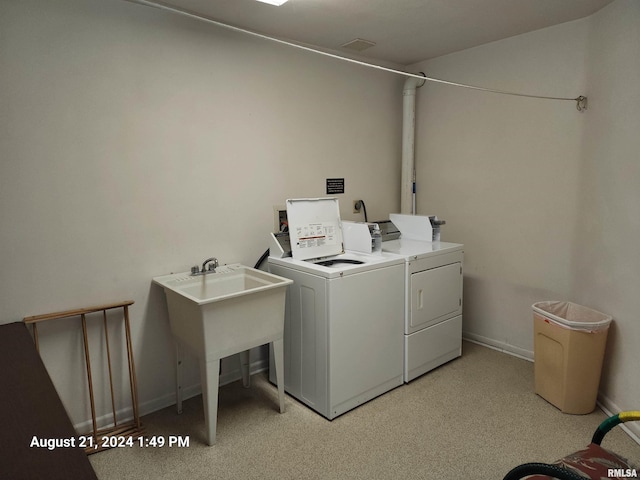 laundry room featuring separate washer and dryer and light carpet