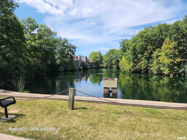 view of dock with a water view and a lawn