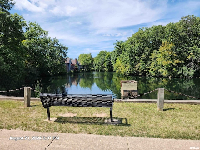 surrounding community with a water view and a yard