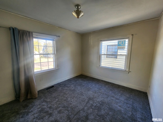 spare room with dark carpet and ornamental molding