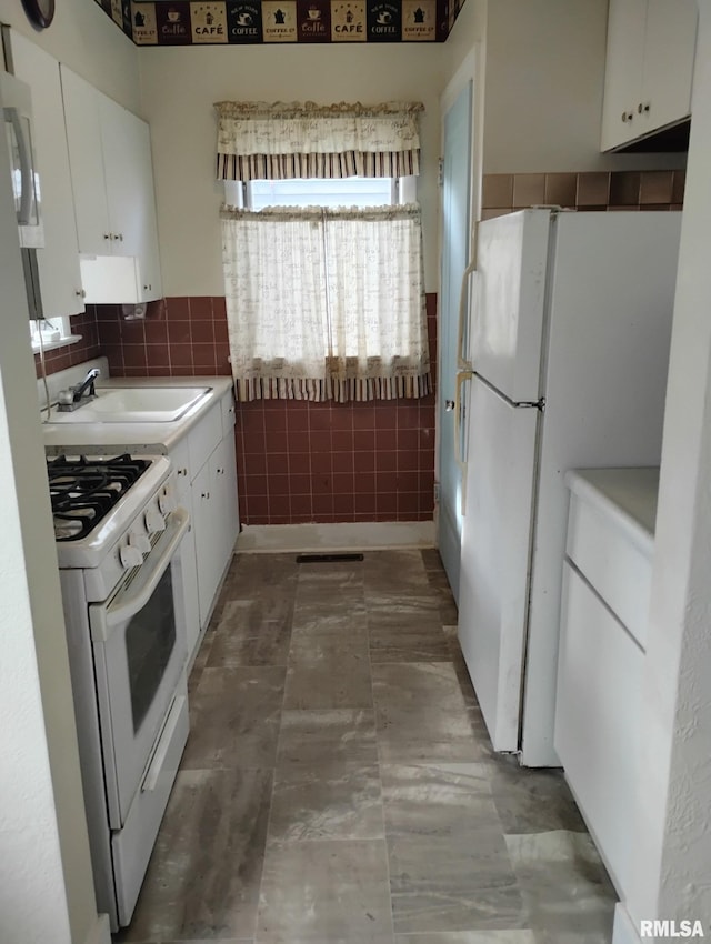 kitchen featuring white cabinets, white appliances, backsplash, and sink