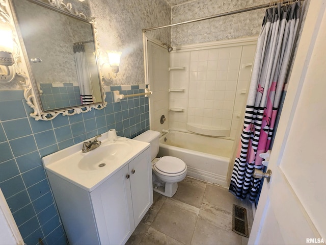 full bathroom with shower / bath combination with curtain, vanity, toilet, and tile walls