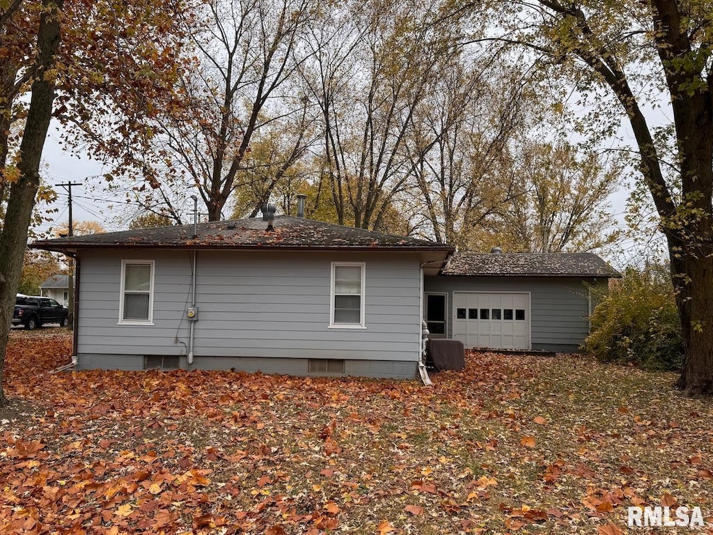 back of house featuring a garage