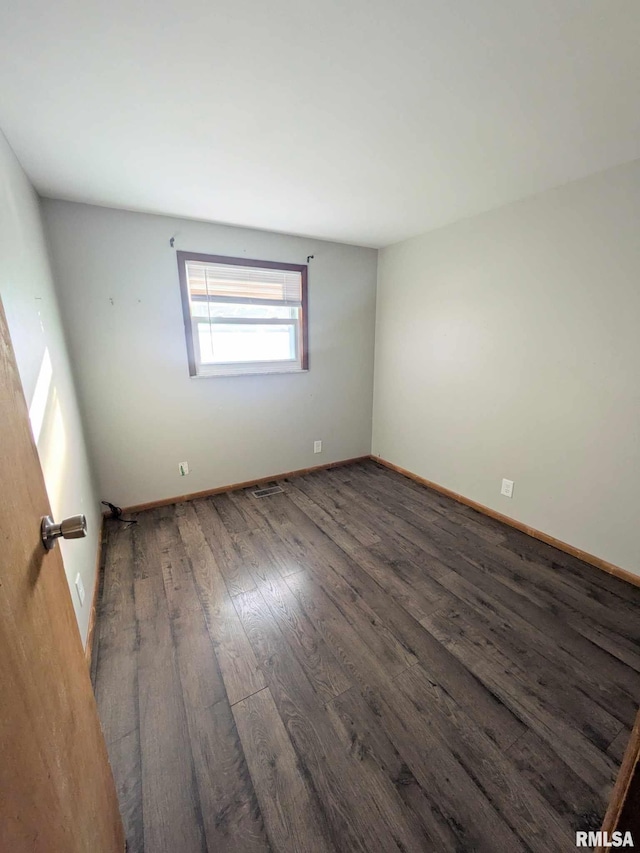 unfurnished room with dark wood-type flooring