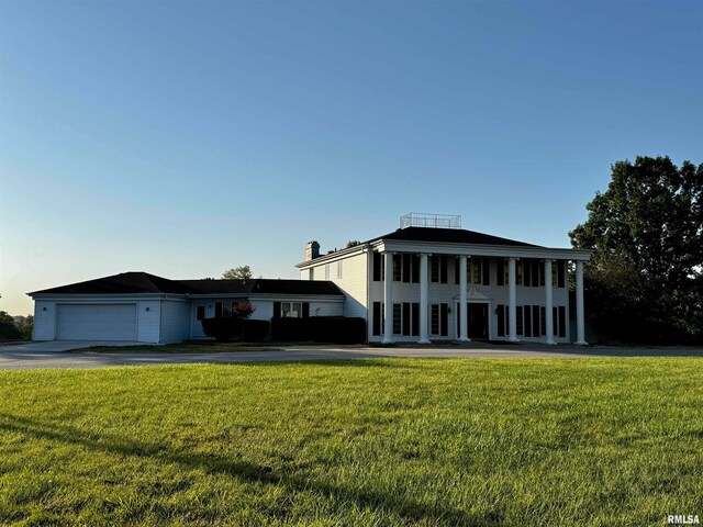 neoclassical / greek revival house featuring a front lawn, a garage, and a porch